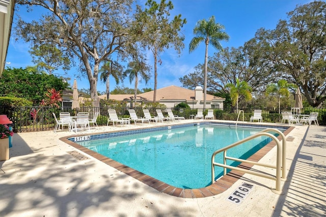 pool featuring fence and a patio