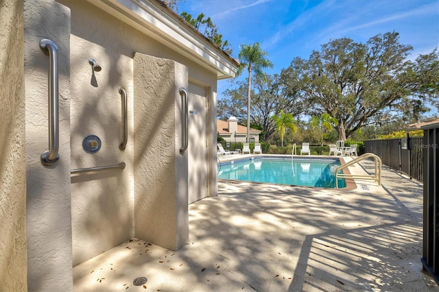 community pool featuring a patio area and fence