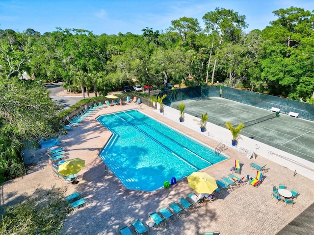 community pool with a tennis court and fence