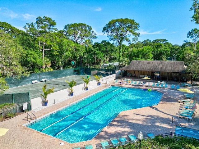 community pool featuring fence and a patio