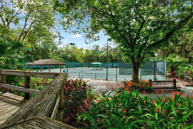 view of tennis court featuring a gazebo and fence