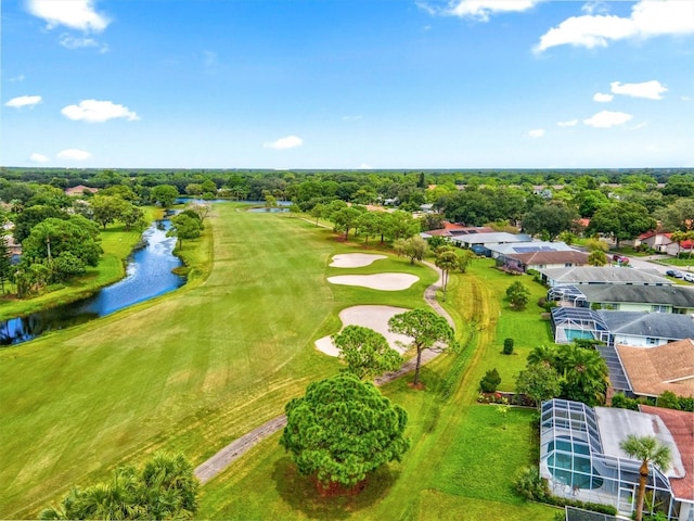 drone / aerial view with view of golf course and a water view