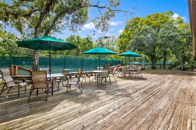 wooden terrace with outdoor dining area and fence