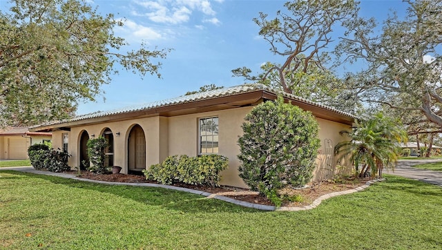 mediterranean / spanish house featuring a front lawn