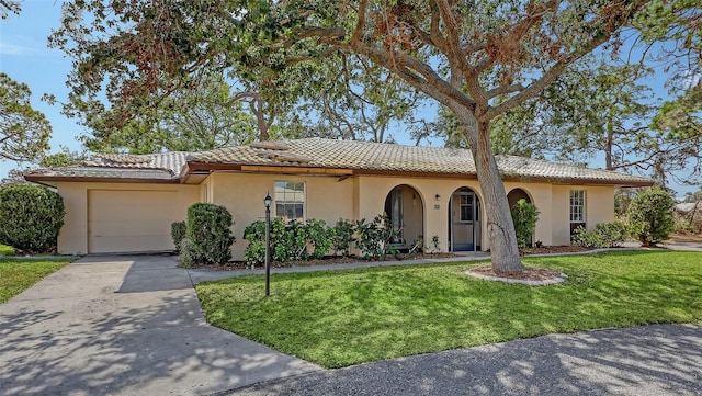 mediterranean / spanish-style home featuring a garage and a front yard