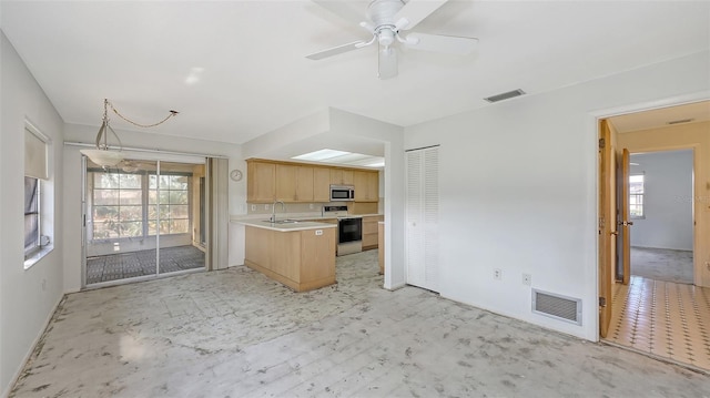 kitchen with plenty of natural light, sink, light brown cabinetry, and electric range