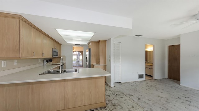 kitchen featuring stainless steel appliances, sink, light brown cabinets, and kitchen peninsula