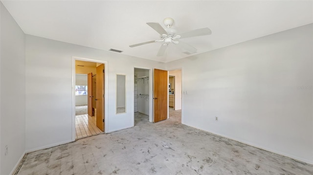 unfurnished bedroom with ceiling fan, a closet, and a walk in closet