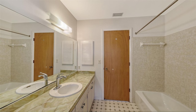 bathroom with vanity and tiled shower / bath