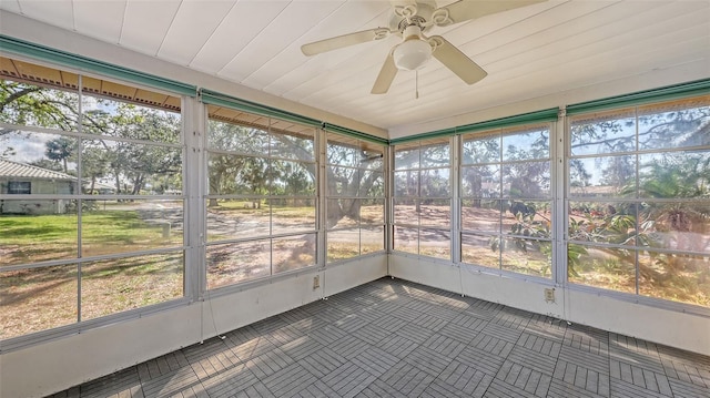 unfurnished sunroom featuring ceiling fan