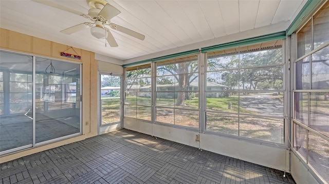 unfurnished sunroom featuring ceiling fan