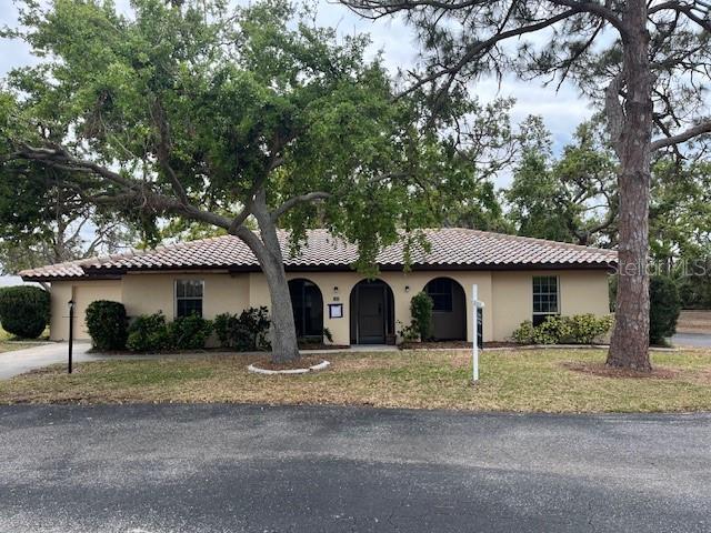 515 Rousseau Dr, Nokomis, FL 34275 - mediterranean / spanish-style house featuring a tiled roof, concrete driveway, and stucco siding