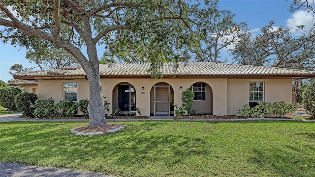 515 Rousseau Dr, Nokomis, FL 34275 - mediterranean / spanish-style home featuring a front yard, stucco siding, and a tiled roof