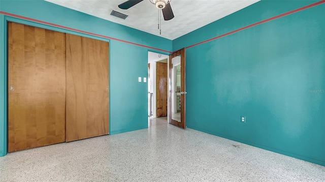 unfurnished bedroom with a closet, visible vents, ceiling fan, and speckled floor