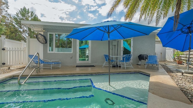 outdoor pool with a patio area and fence