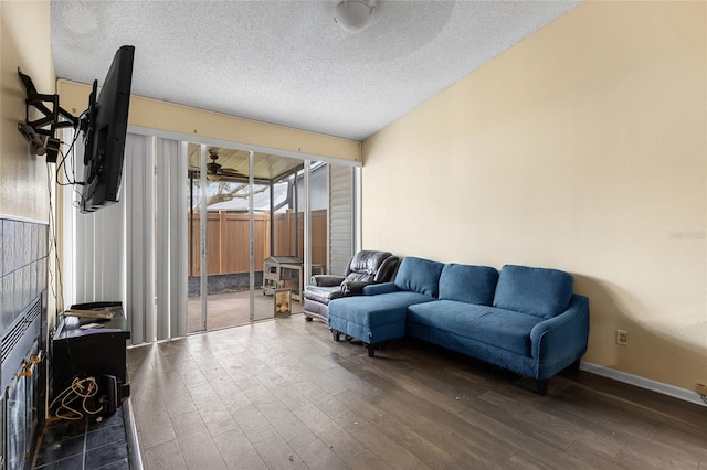 living area with a sunroom, ceiling fan, dark wood finished floors, and a textured ceiling