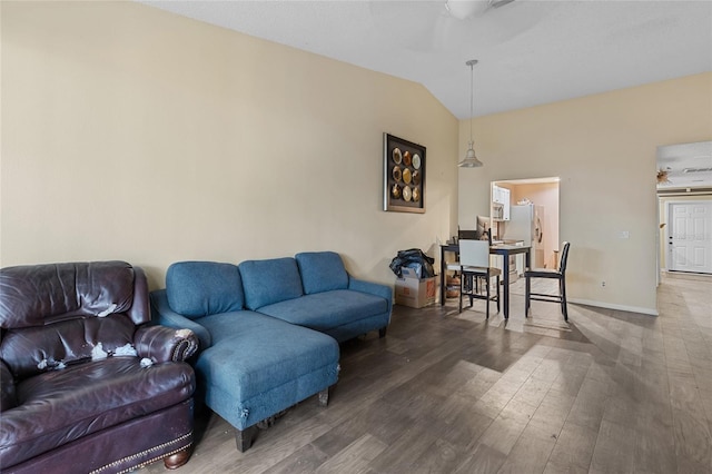 living room with lofted ceiling, dark wood-style flooring, a ceiling fan, and baseboards