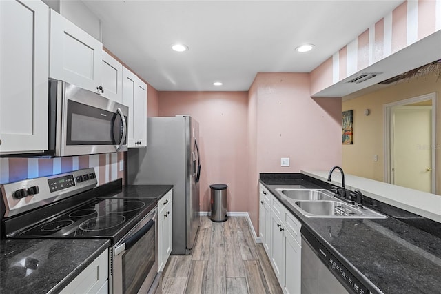 kitchen featuring light wood-style floors, white cabinetry, stainless steel appliances, and a sink