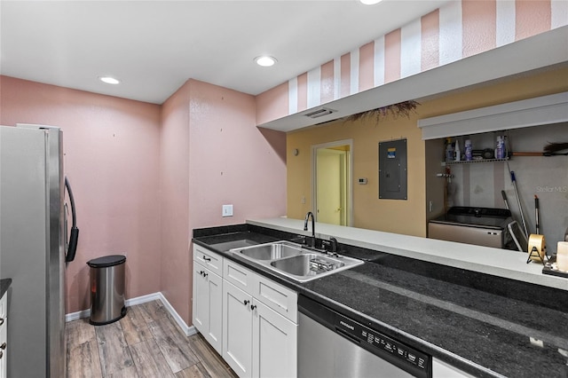 kitchen with stainless steel appliances, visible vents, white cabinetry, a sink, and electric panel