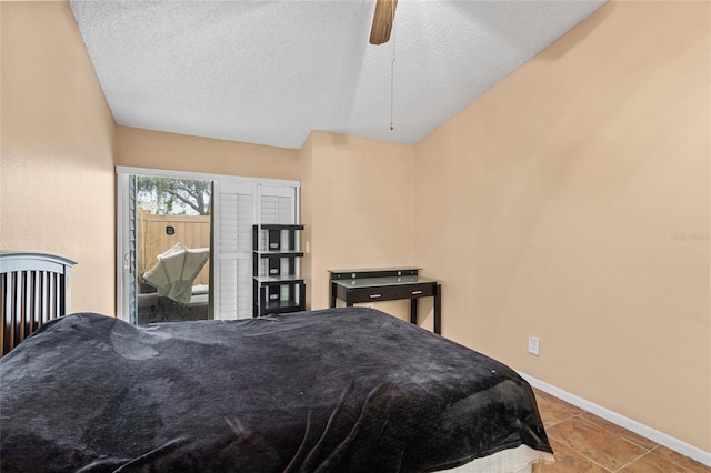 bedroom with ceiling fan, baseboards, and a textured ceiling