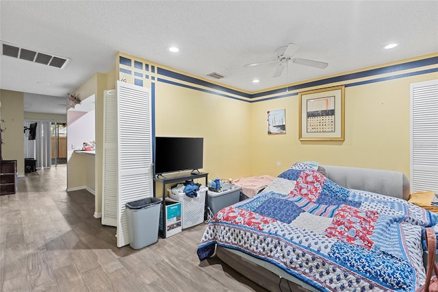 bedroom featuring a textured ceiling, wood finished floors, and visible vents