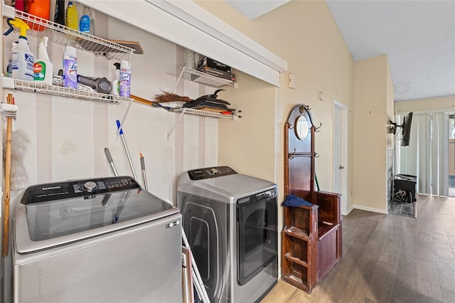 laundry room featuring a textured ceiling, laundry area, wood finished floors, baseboards, and washer and dryer