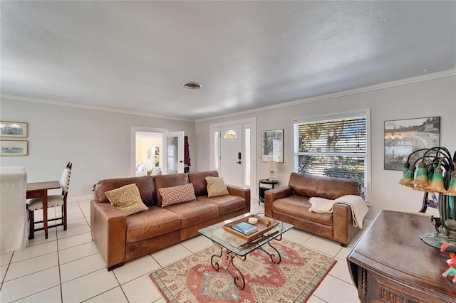 living room featuring light tile patterned floors, baseboards, visible vents, and crown molding