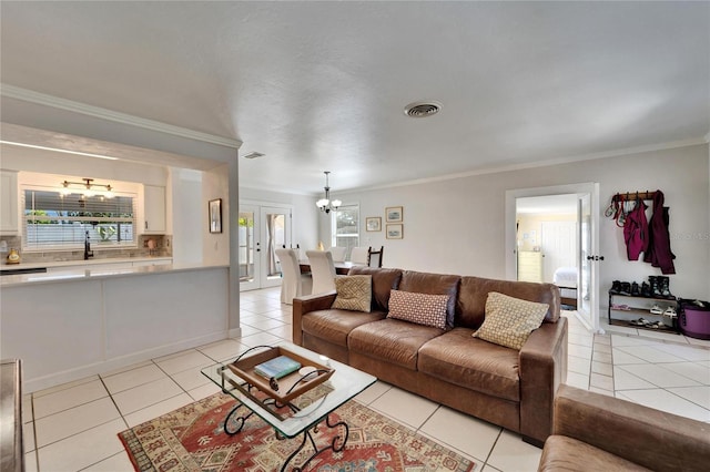 living area with a notable chandelier, visible vents, crown molding, and light tile patterned flooring