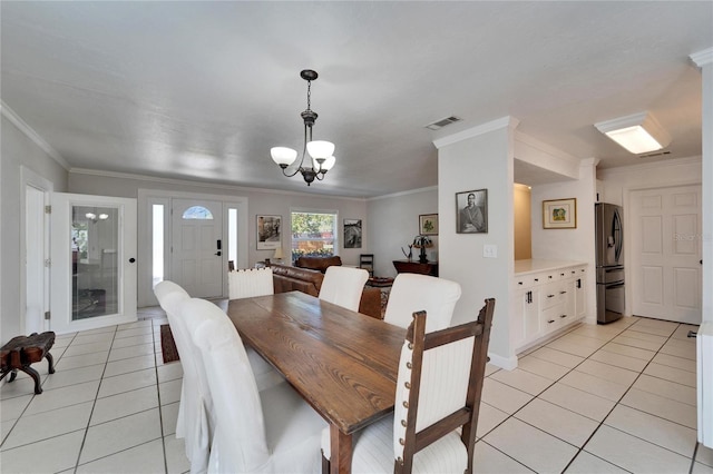 dining area with light tile patterned floors, ornamental molding, visible vents, and a notable chandelier