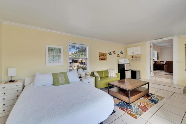 bedroom with freestanding refrigerator, visible vents, crown molding, and light tile patterned floors