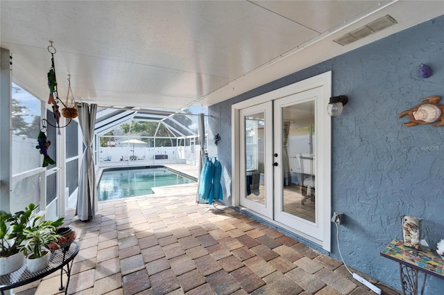 view of pool with glass enclosure, french doors, a fenced in pool, and a patio