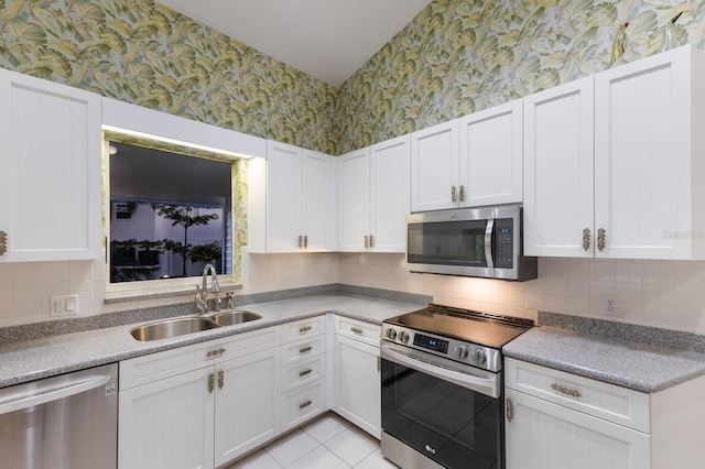 1528 43rd Avenue Dr W, Palmetto, FL 34221 - kitchen featuring a sink, wallpapered walls, white cabinets, and stainless steel appliances