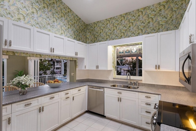 1528 43rd Avenue Dr W, Palmetto, FL 34221 - kitchen with wallpapered walls, white cabinets, range with electric stovetop, stainless steel dishwasher, and a sink