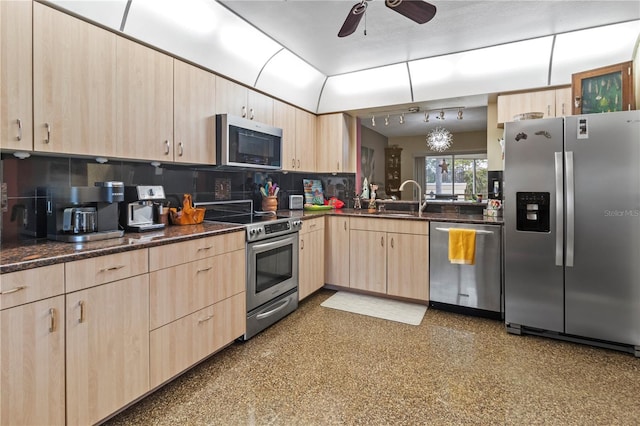 kitchen with a ceiling fan, appliances with stainless steel finishes, vaulted ceiling, light brown cabinets, and a sink