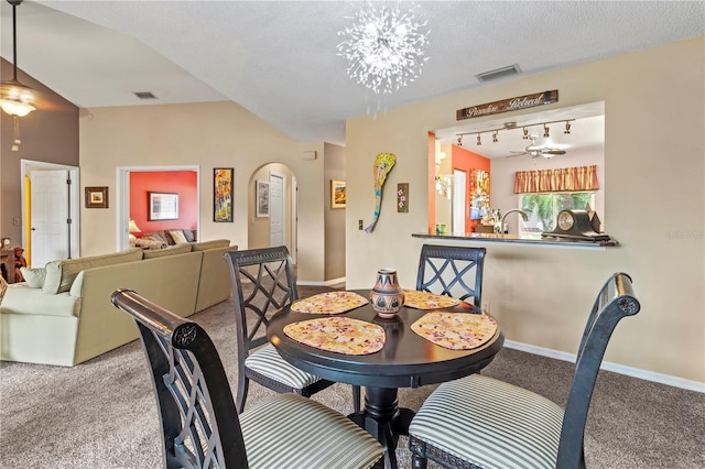 carpeted dining space featuring arched walkways, visible vents, a textured ceiling, and baseboards