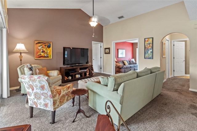 living area featuring high vaulted ceiling, visible vents, arched walkways, and carpet flooring