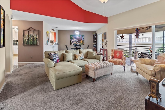 carpeted living area with a ceiling fan, lofted ceiling, and baseboards