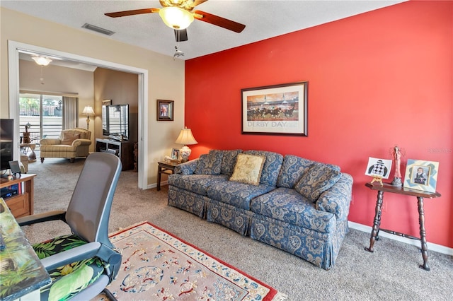 carpeted living area featuring visible vents, ceiling fan, a textured ceiling, and baseboards