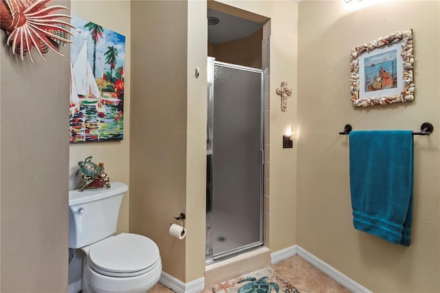 bathroom featuring baseboards, a stall shower, toilet, and tile patterned floors