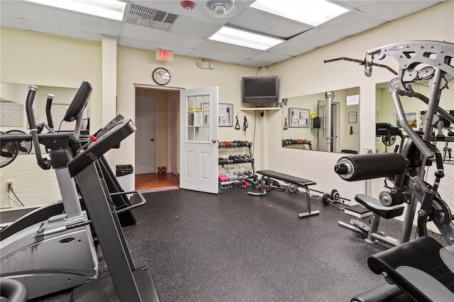 gym with a paneled ceiling and visible vents