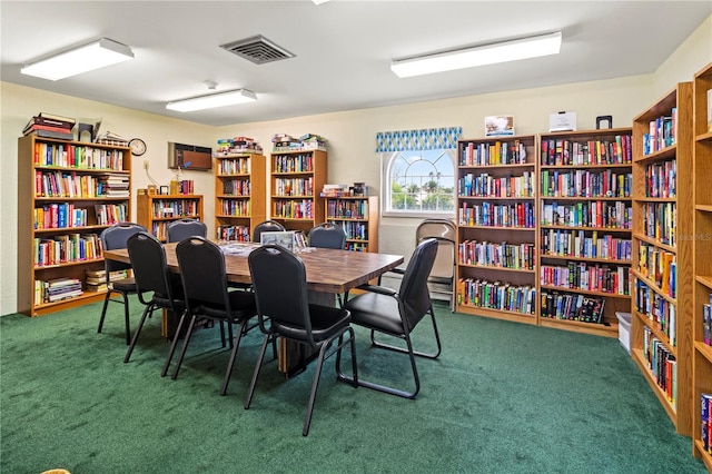 interior space with bookshelves, visible vents, and carpet flooring