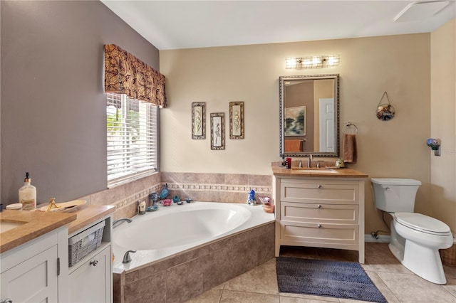 bathroom with a garden tub, vanity, toilet, and tile patterned floors