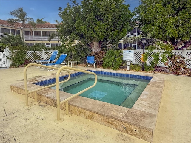 view of pool with a patio area and fence