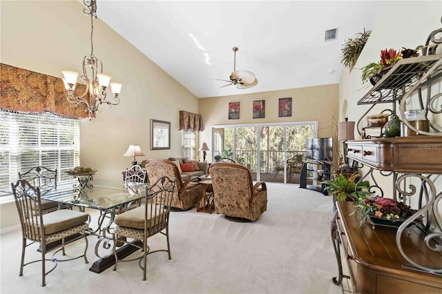 carpeted dining space featuring lofted ceiling and ceiling fan with notable chandelier