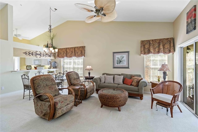 living room with high vaulted ceiling, light colored carpet, a healthy amount of sunlight, and ceiling fan with notable chandelier