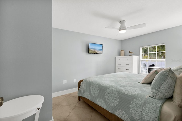 bedroom with a ceiling fan, baseboards, and light tile patterned floors