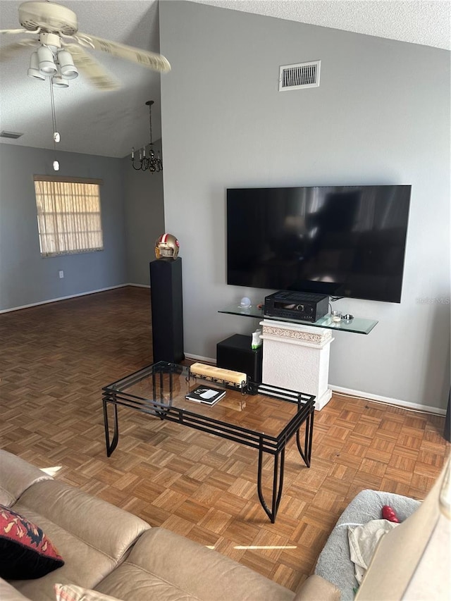 living room with a ceiling fan, visible vents, and vaulted ceiling