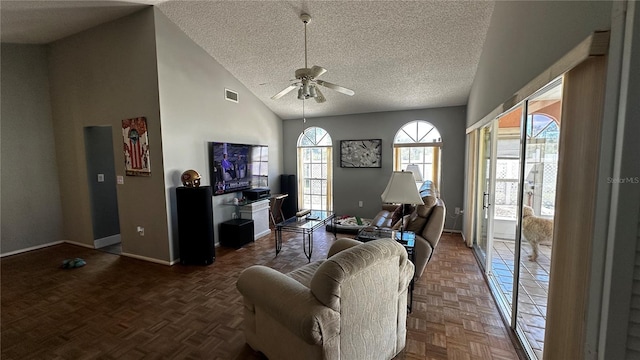 living area featuring a textured ceiling, high vaulted ceiling, visible vents, a ceiling fan, and baseboards