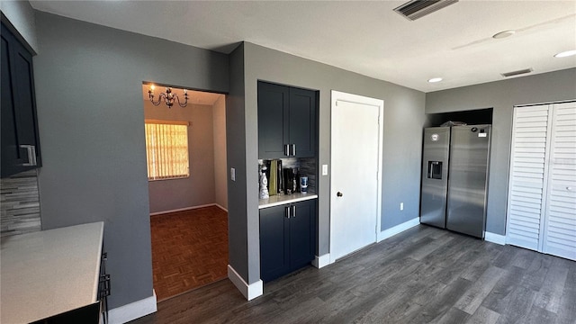 kitchen featuring visible vents, baseboards, light countertops, parquet floors, and stainless steel fridge with ice dispenser