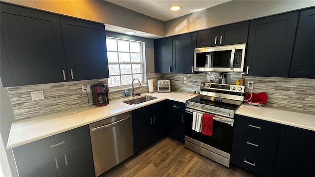 kitchen with stainless steel appliances, a sink, and light countertops